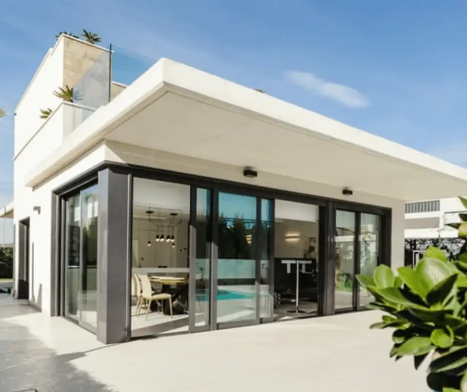 Modern smart home with large glass windows and bright exterior, symbolizing remote environmental monitoring with MarCELL.